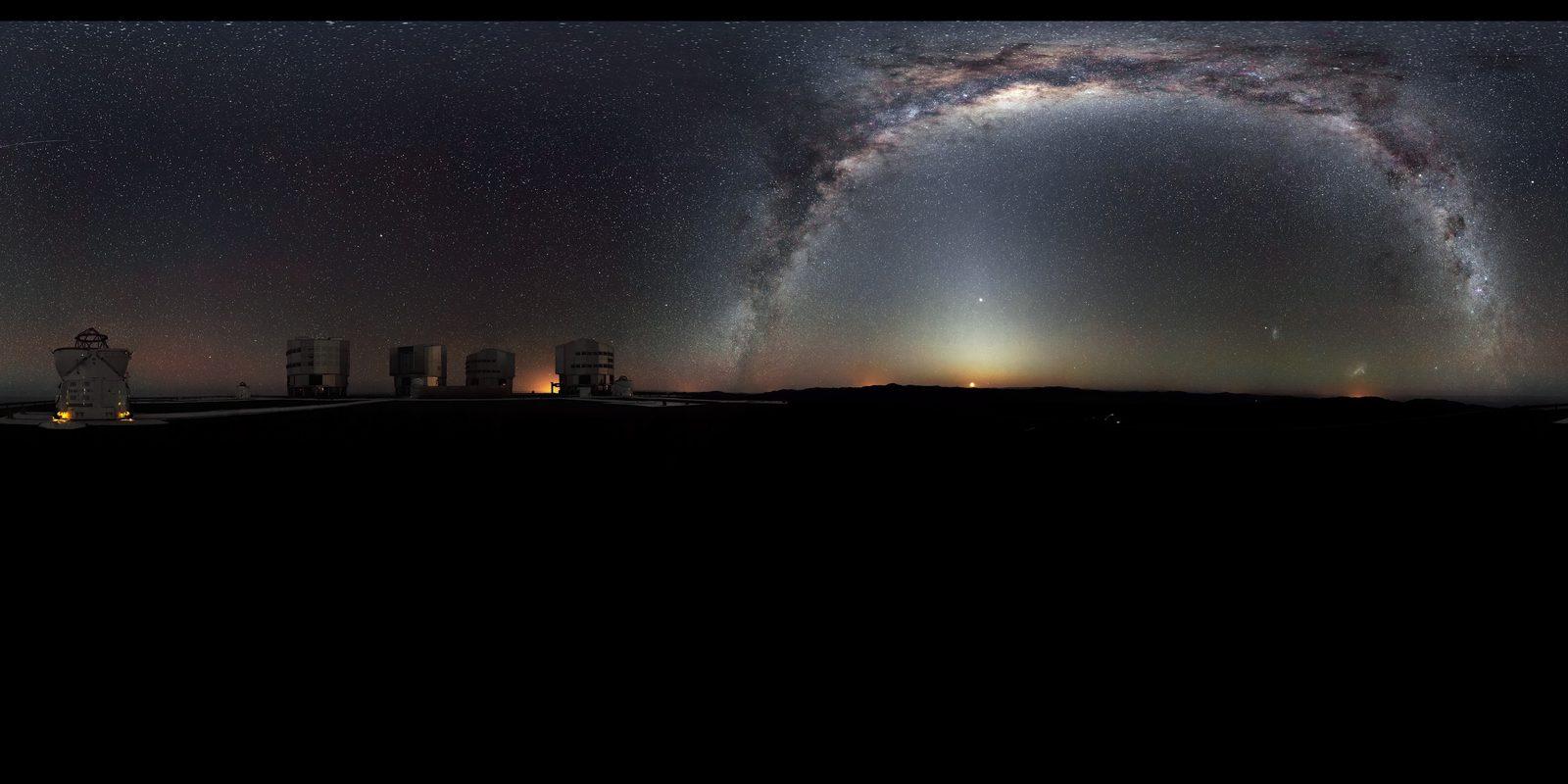 Panorámica nocturna de la plataforma del VLT, con sus cuatro grandes telescopios de 8,2 m alineados bajo la Vía Láctea y las Nubes de Magallanes.