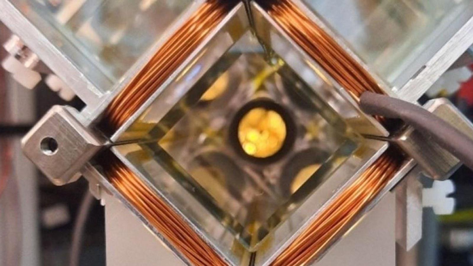 The 2D MOT experimental apparatus: a vacuum glass cell at its center, surrounded by magnetic coils and metal optical components, cooling rubidium atoms before their transfer to the chip.