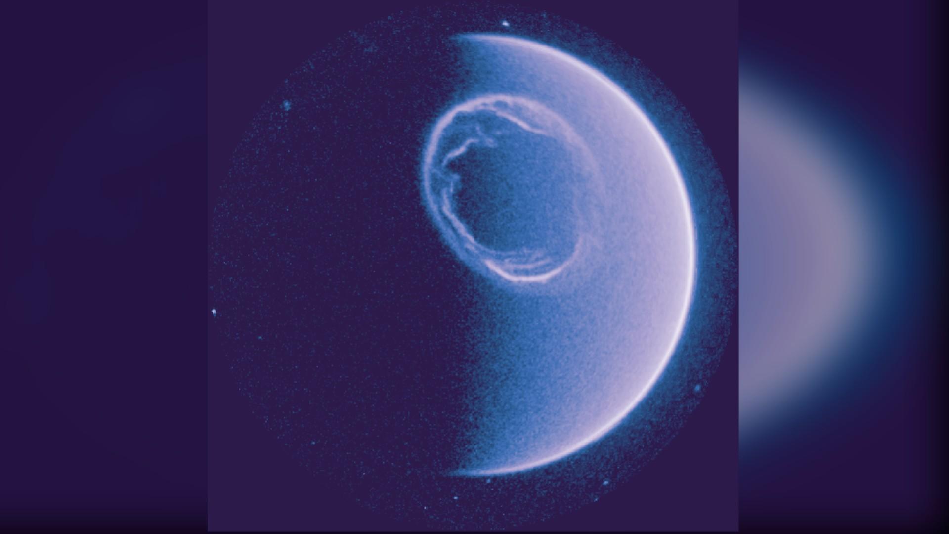 Vue ultraviolette de la Terre par la caméra UVI de Smile : un anneau blanc brillant et tourbillonnant entoure le pôle Nord sur un disque bleu pâle, sur fond d'étoiles.