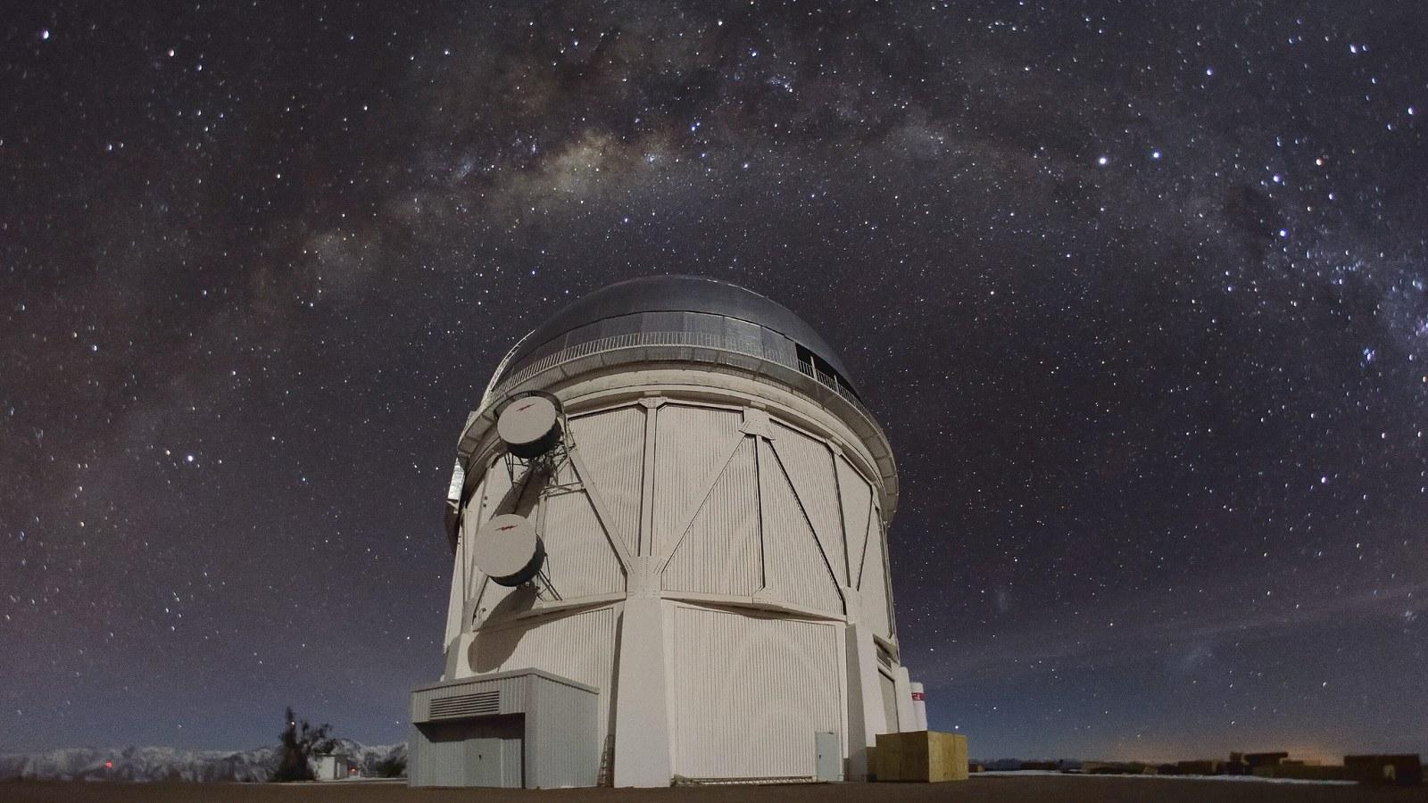 Le dôme du télescope Victor Blanco à l'observatoire de Cerro Tololo, au Chili, sous un ciel étoilé traversé par la Voie lactée.