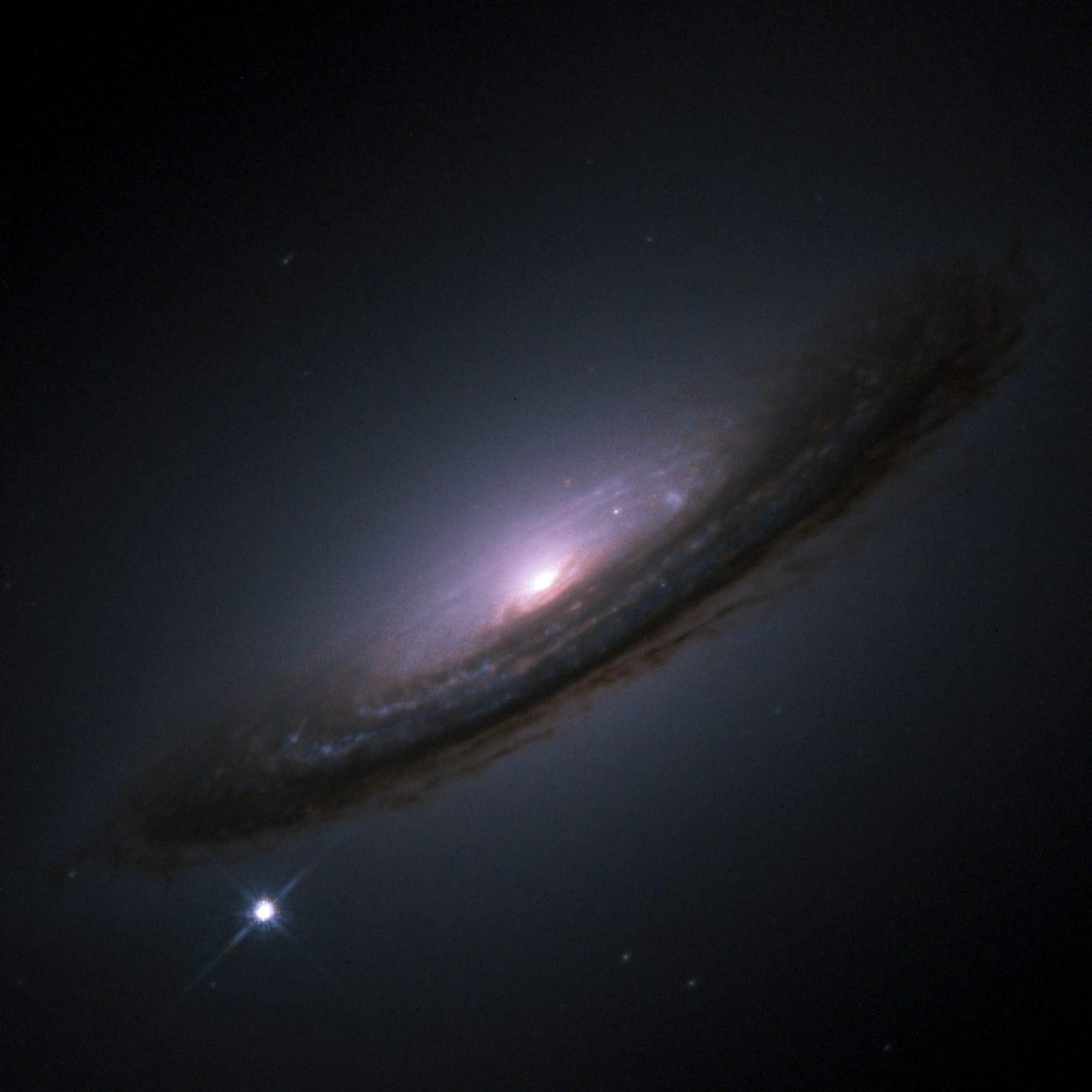 La supernova 1994D vista como un punto brillante en la parte inferior izquierda de la galaxia NGC 4526, fotografiada por el telescopio espacial Hubble.