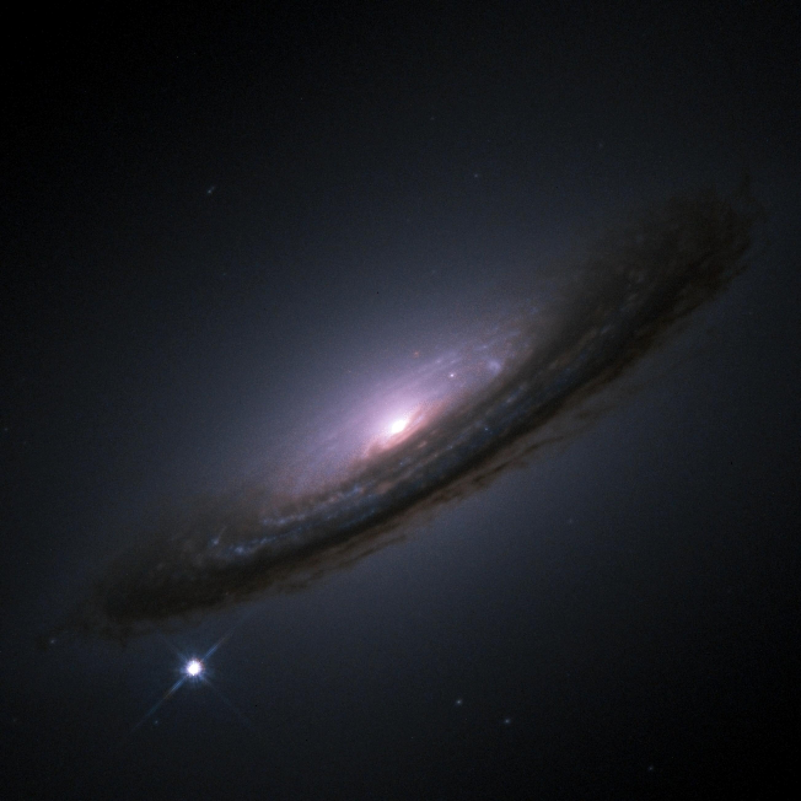 La supernova 1994D vue comme un point brillant dans le bas gauche de la galaxie NGC 4526, photographiée par le télescope spatial Hubble.