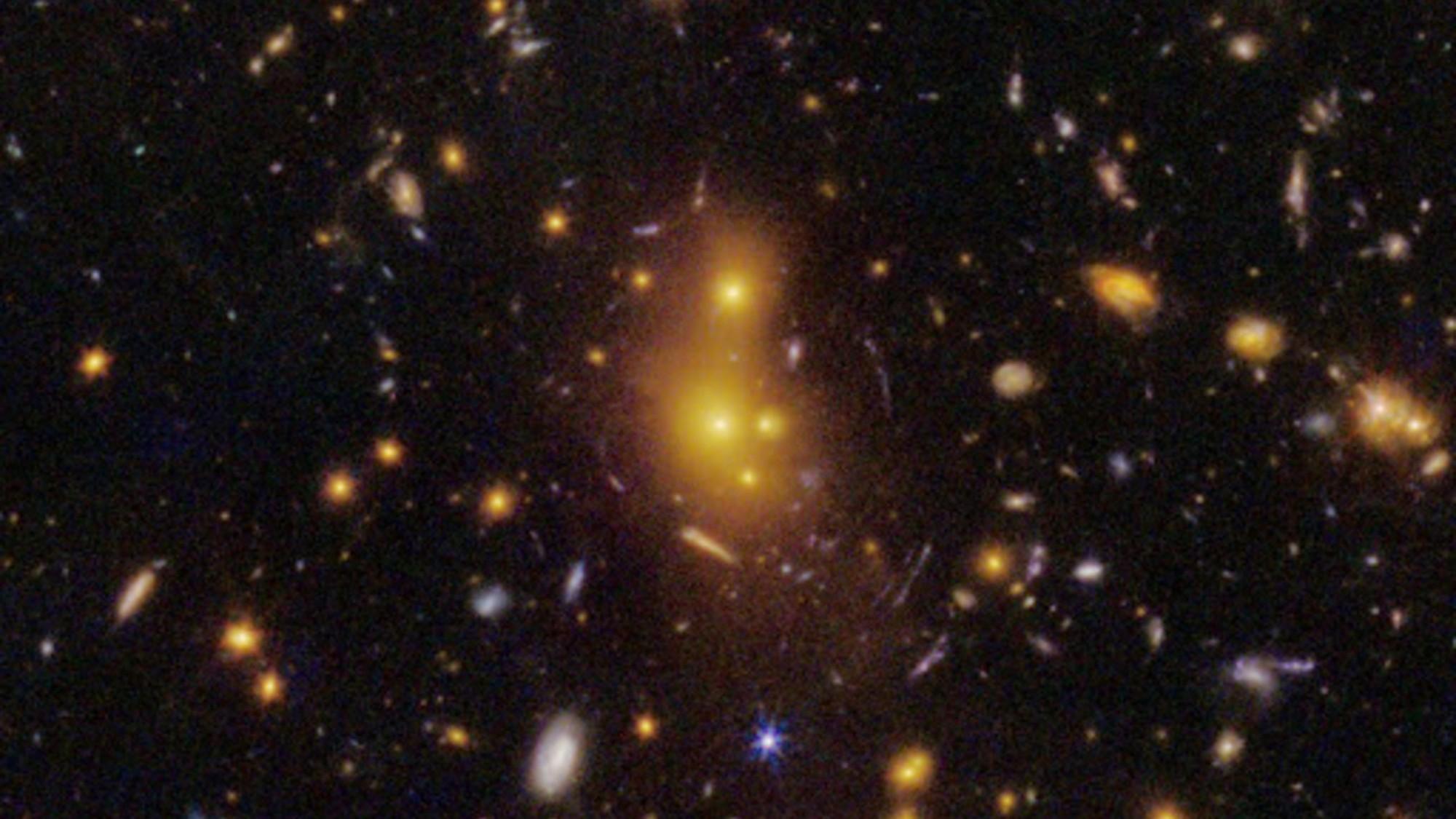 Dos imágenes del mismo cúmulo de galaxias una al lado de la otra: a la izquierda la de Hubble, a la derecha la del James Webb, donde arcos azulados de luz rodean el núcleo anaranjado.