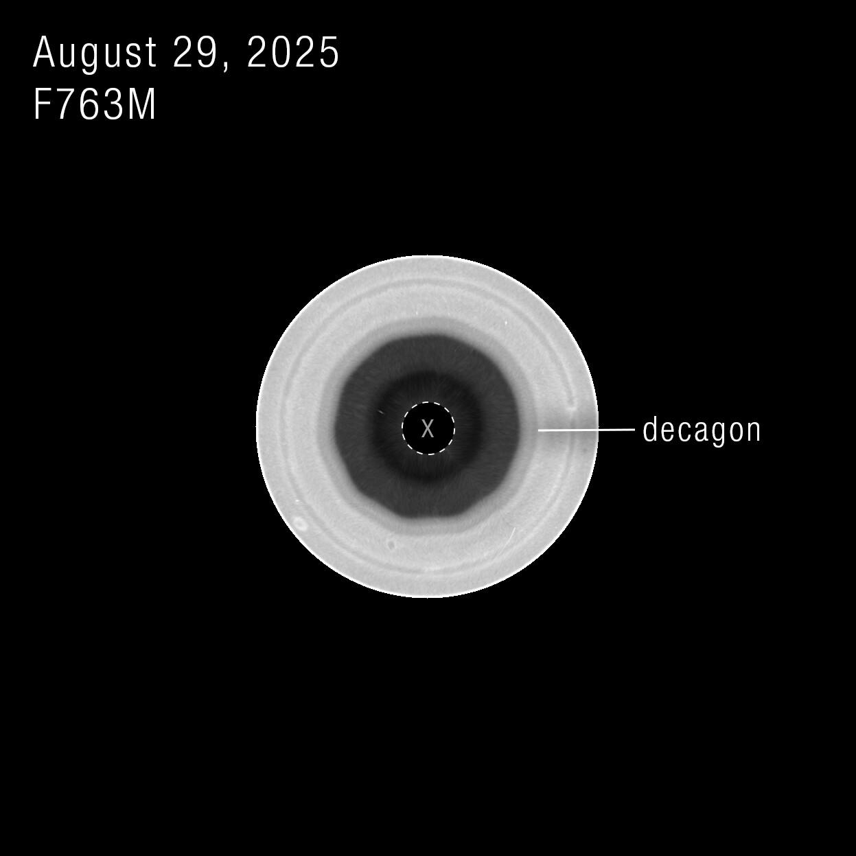 Vista en blanco y negro del polo sur de Saturno en un solo filtro de Hubble: el contorno decagonal se ve con claridad alrededor de la región oscura.