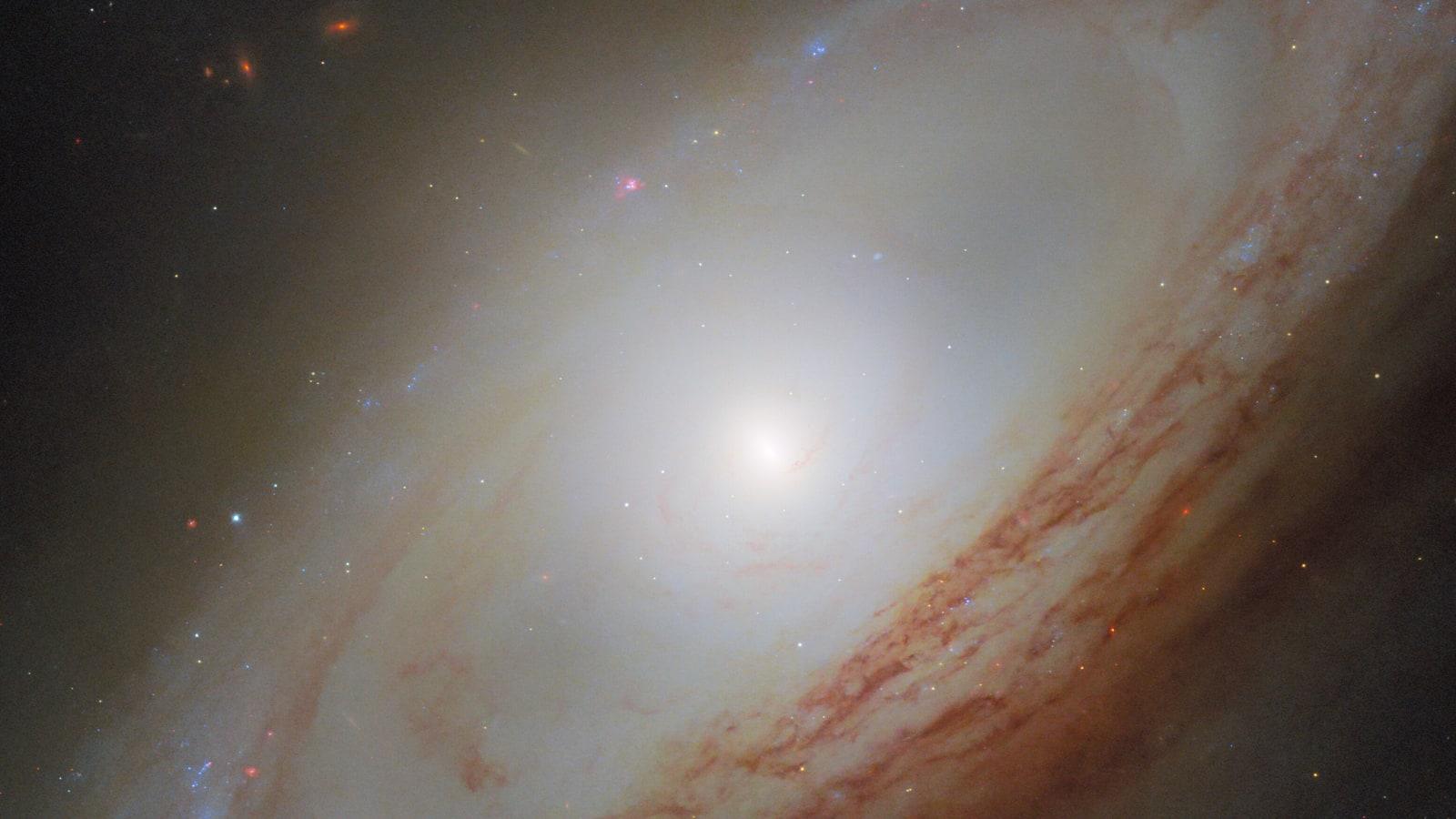 The spiral galaxy NGC 4698 seen by Hubble, with a bright central bulge and spiral arms forming a ring around the disk.
