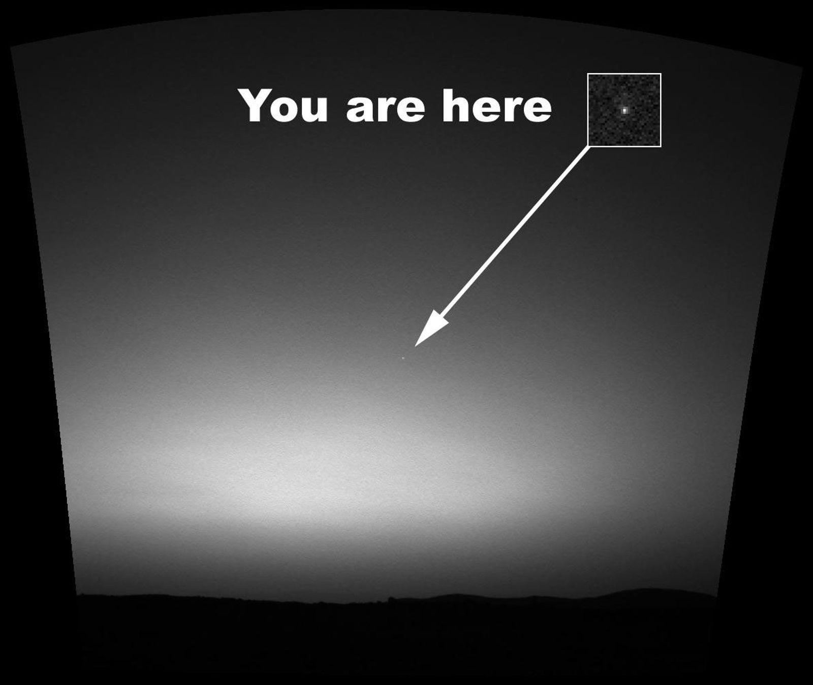 Mosaico de la cámara de navegación del rover Spirit, marzo de 2004: el cielo marciano al alba, con un recorte ampliado que muestra a la Tierra, un punto brillante señalado con una flecha.