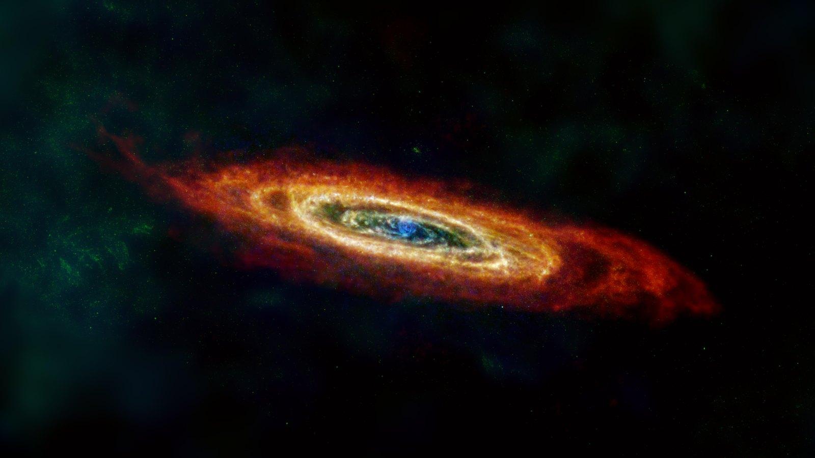 La galaxie d'Andromède vue dans l'infrarouge lointain : un disque incliné où les bras spiraux apparaissent sous forme de rubans de poussière chaude, dans des teintes orangées et bleutées.
