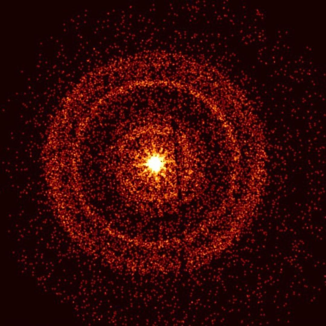 Imagen de rayos X del estallido GRB 221009A: anillos concéntricos de color marrón rojizo en torno a una fuente central amarilla muy brillante.