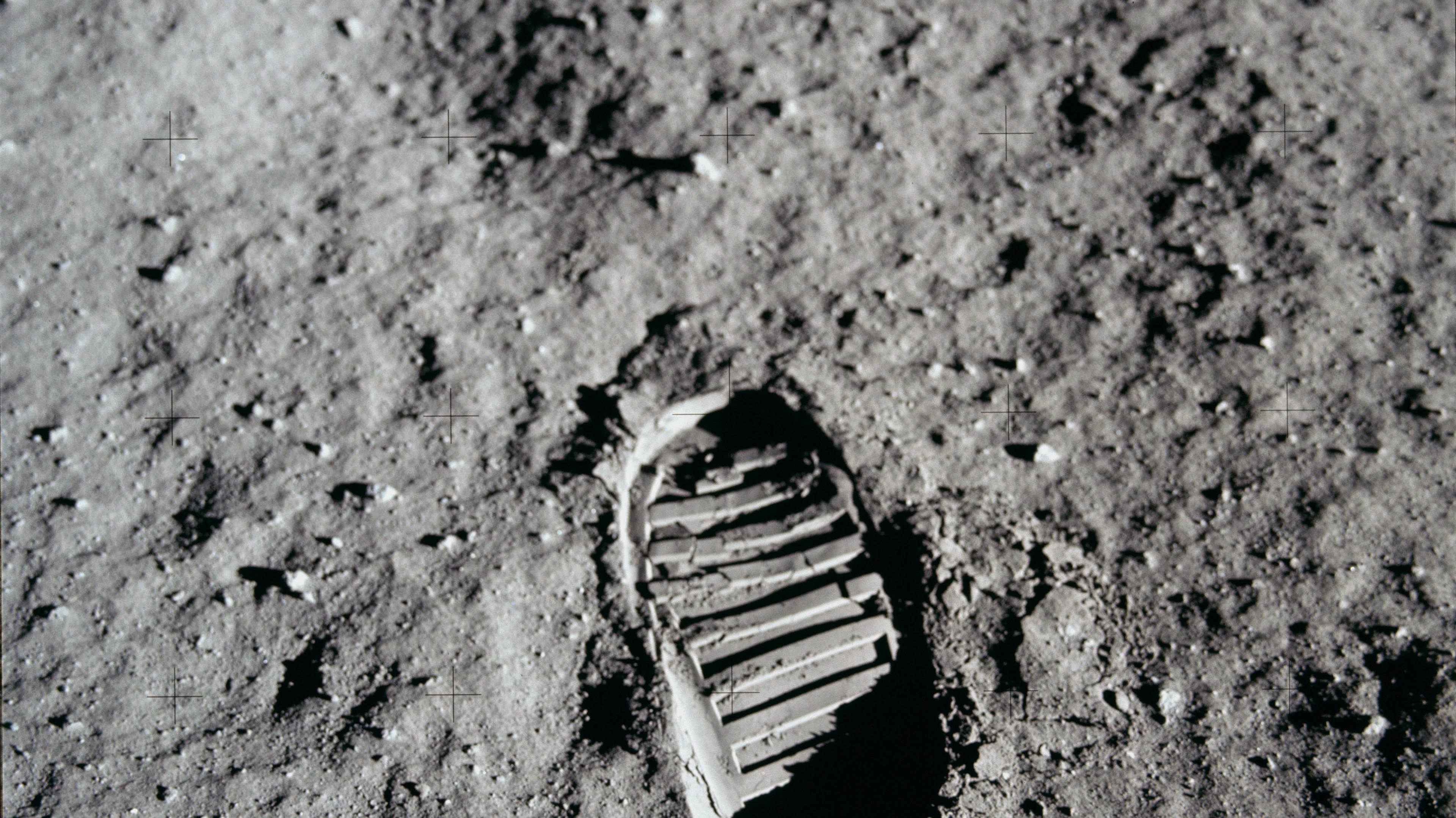 An Apollo 11 bootprint pressed into lunar regolith, lit by a low Sun.