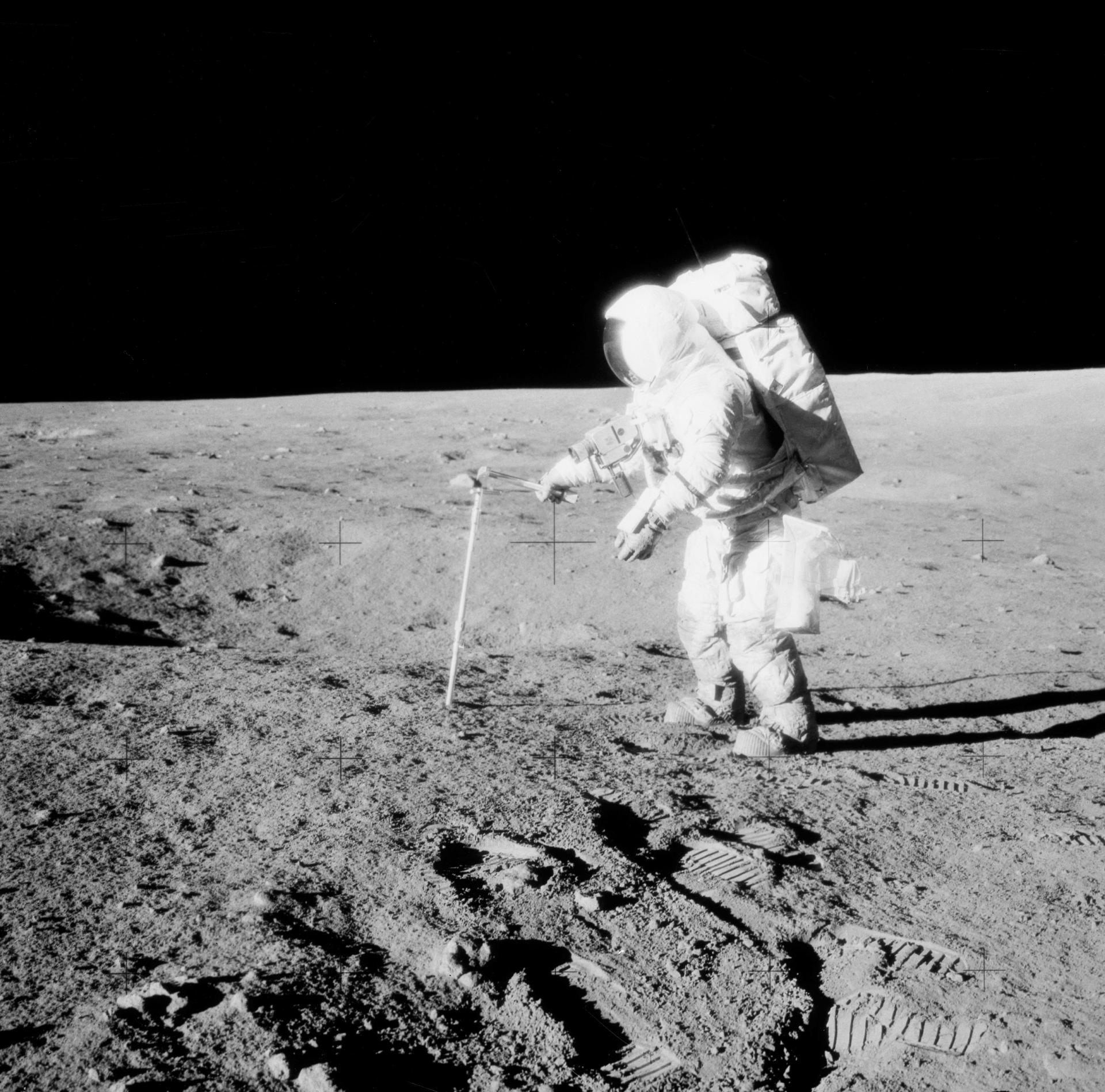 Astronaut Alan Bean drives a core sample tube into the lunar soil during the Apollo 12 mission.
