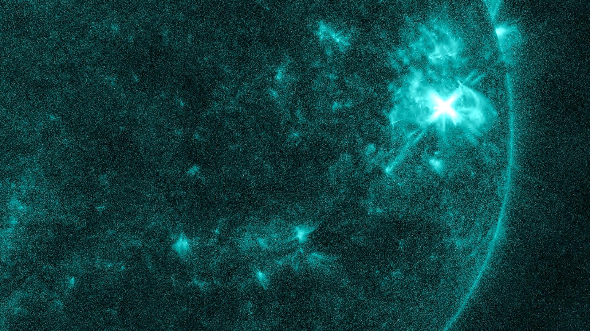 Le Soleil en ultraviolet extrême, teinté de bleu-vert. Près du bord droit, une tache très brillante en forme d'étoile marque l'éruption M6.4 de la région active AR 4549.