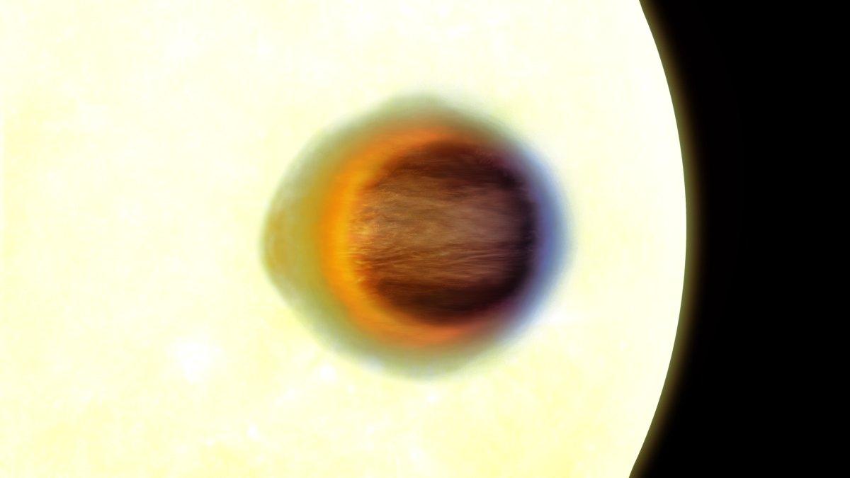 WASP-17b vista de frente durante su tránsito: el disco oscuro del planeta recorta un creciente de luz estelar, con un limbo atmosférico azul a la izquierda y un limbo rojo anaranjado más grueso a la derecha.